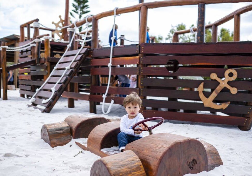 Young chiild playing in wooden car at Flinders Bay playground, Augusta